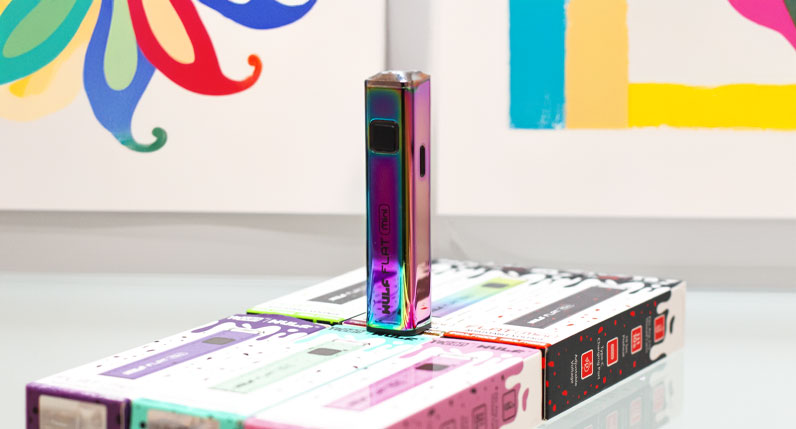 Wulf Flat Mini resting on packaging in front of white wall with art