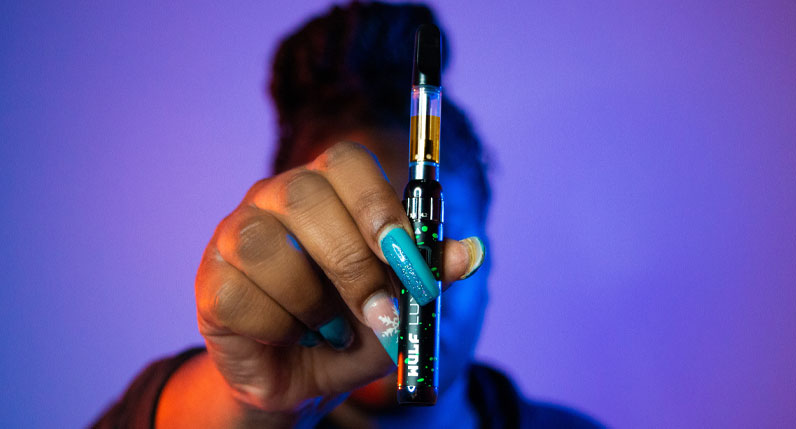 Woman holding the Wulf LUX in front of her inside studio with blue background