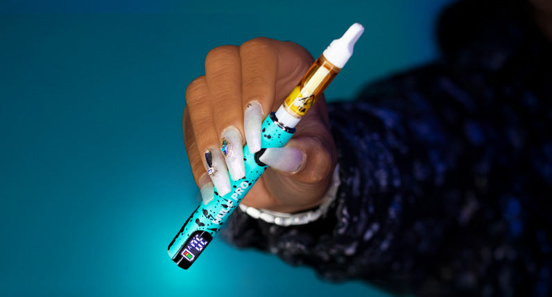 Hand holding a WULF Pro 510 thread battery with a cartridge attached under blue lighting