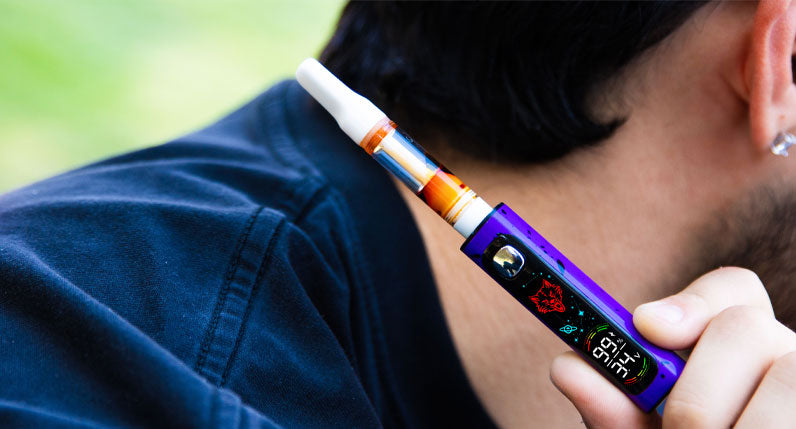 Person holding a WULF Pro Digit 510 thread battery with a cartridge attached