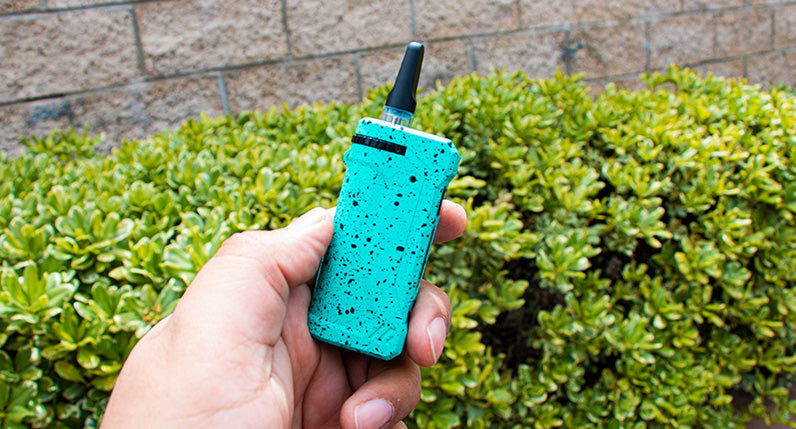 man holding the Teal and Black Spatter Wulf UNI Pro outside