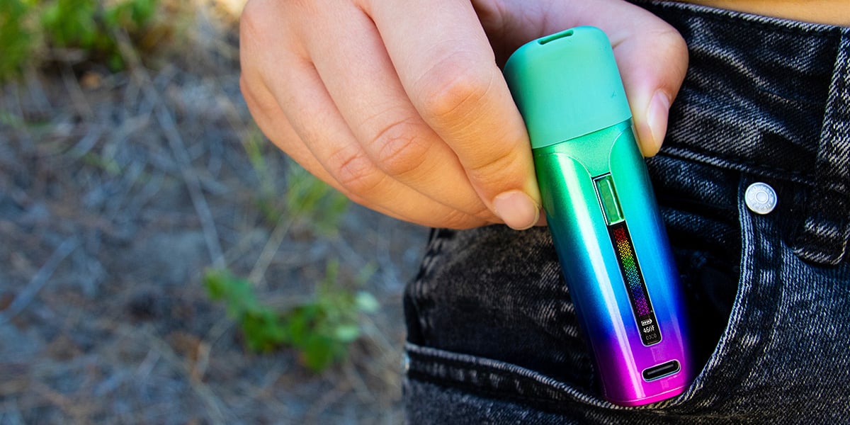 woman holding the wulf mods pocket mini concentrate vaporizer lifestyle image in full color